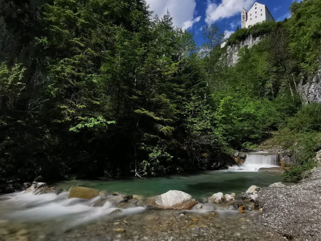 Šlapeme po široké cestě za soutěskou ke skalnímu klášteru v Tyrolsku, nahoře je hostinec a krásný výhled na Stanser Joch