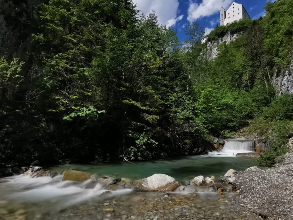 We wandelen over het brede pad achter de kloof naar het rotsklooster in Tirol, daarboven is de herberg en een geweldig uitzicht op de Stanser Joch